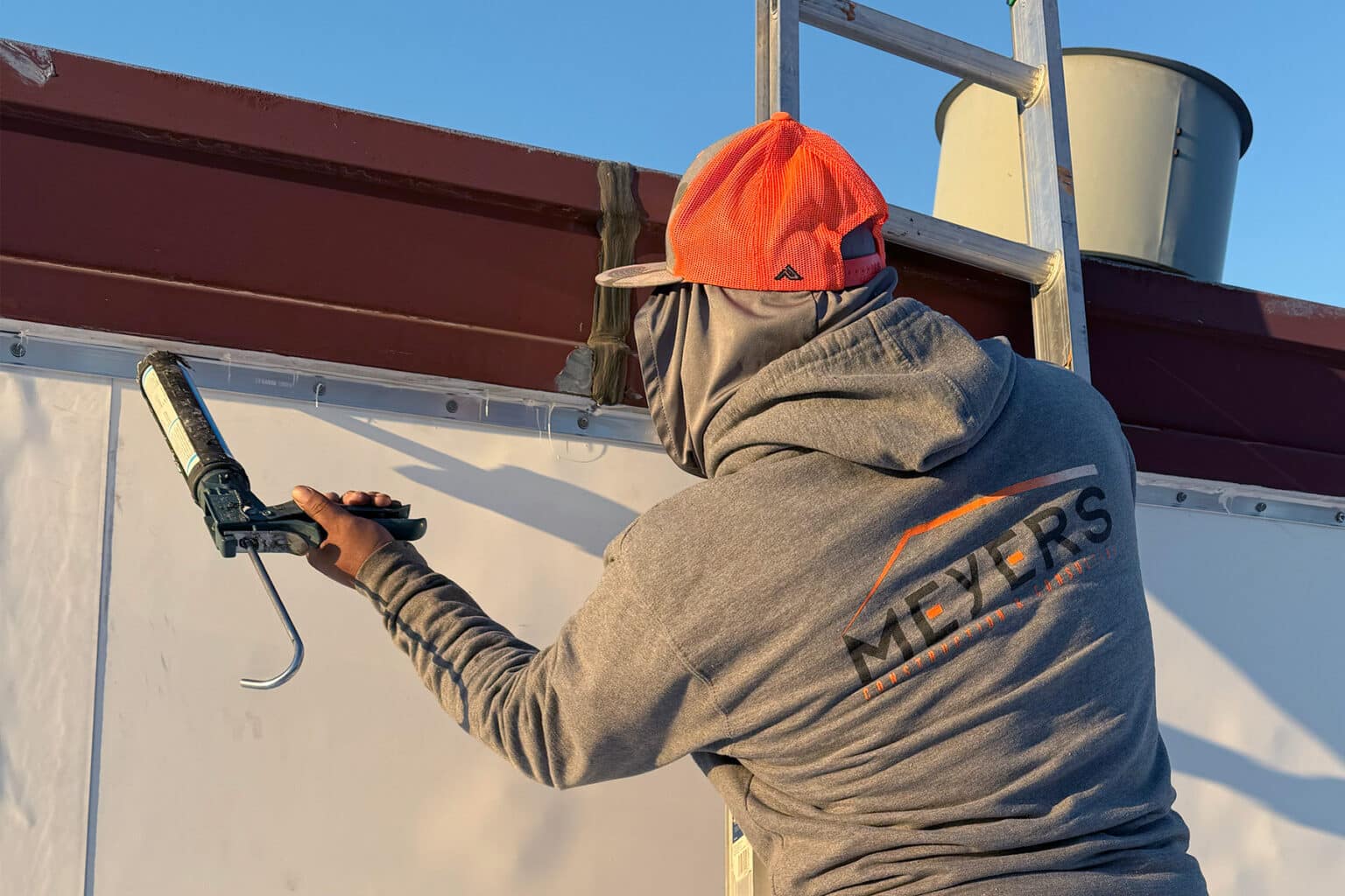 Worker caulks a seam on a flat roof.